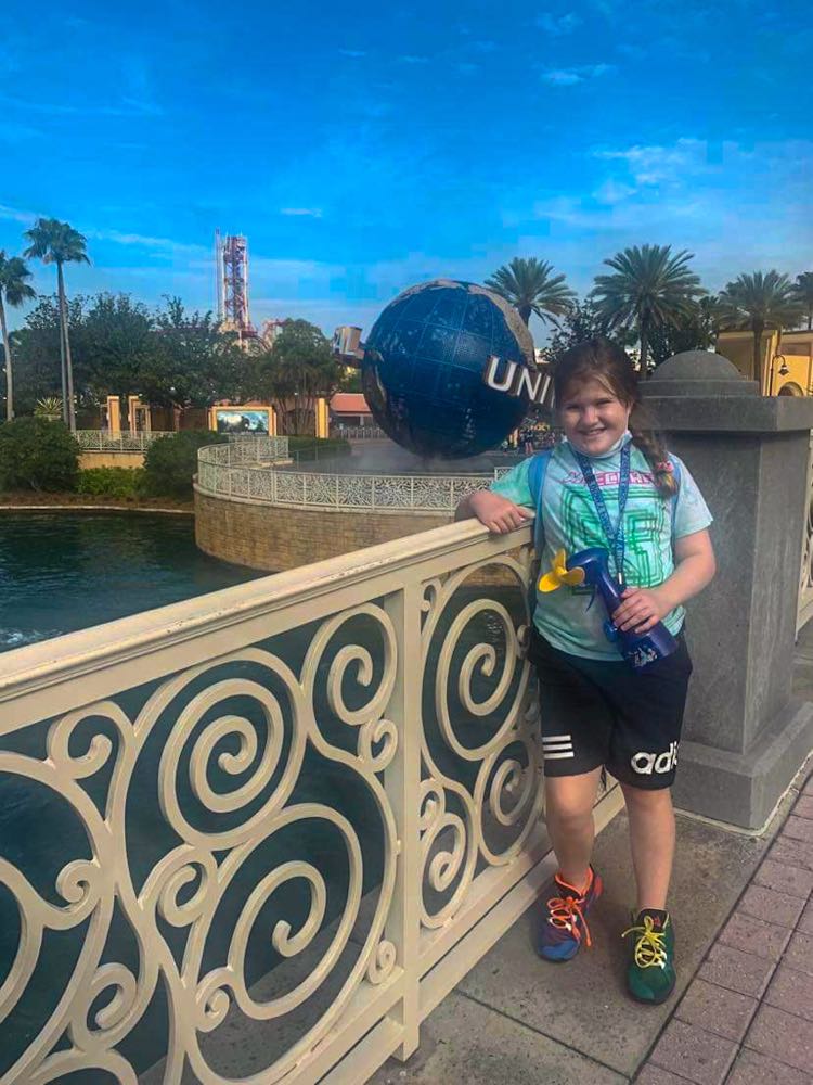 My little sister standing in front of universal studios globe