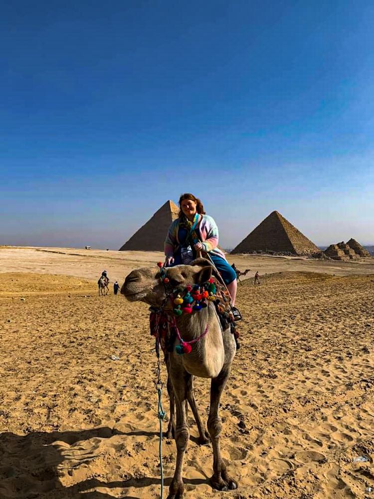 Me riding camel in front of pyramids