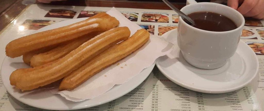 Churros with a cup of melted chocolate